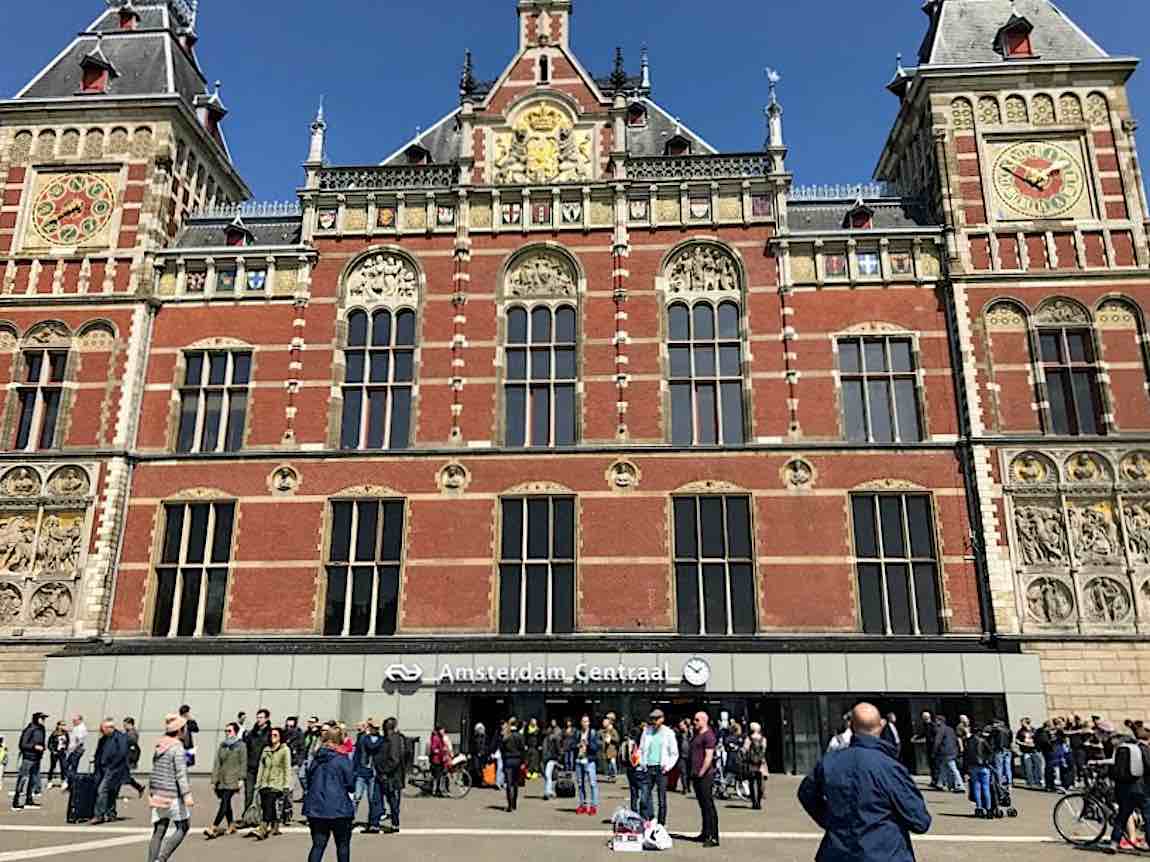 The main entrance to Amsterdam Centraal Station with people milling around.