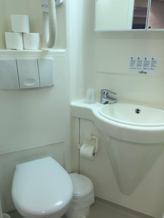 Clean and compact, with shower, hair dryer and storage in the medicine cabinet.