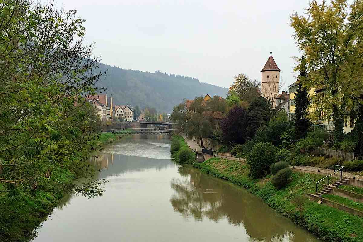 Quiet canal flowing through town, with narrow bridges connecting both sides.