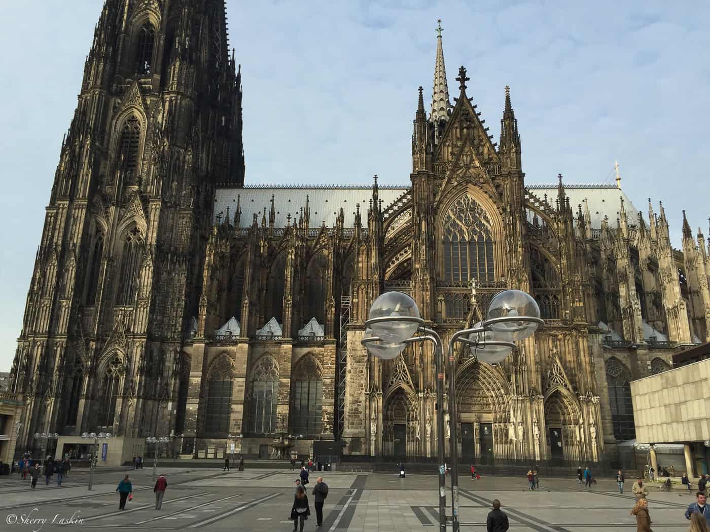 front view of Cologne Cathedral with spires and tower.