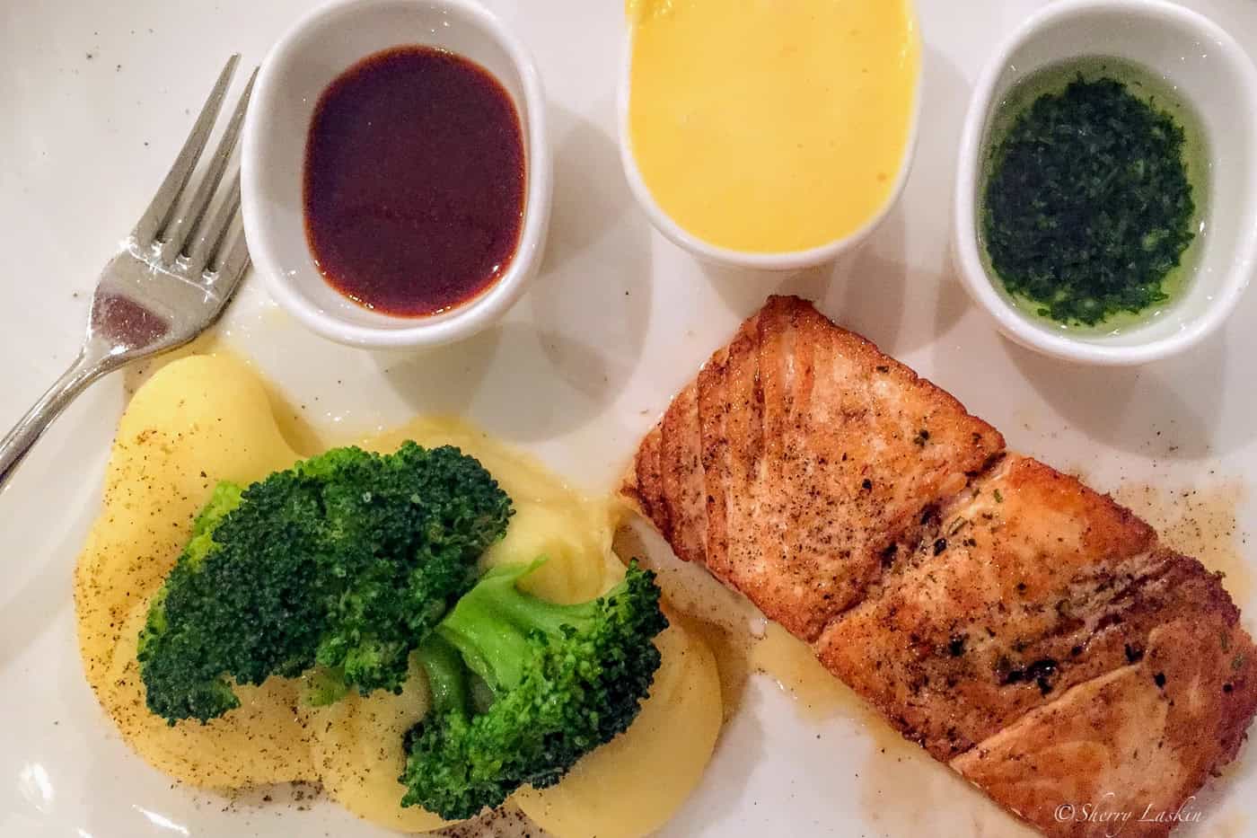 Dinner plate with grilled salmon, broccoli and mashed potatoes.