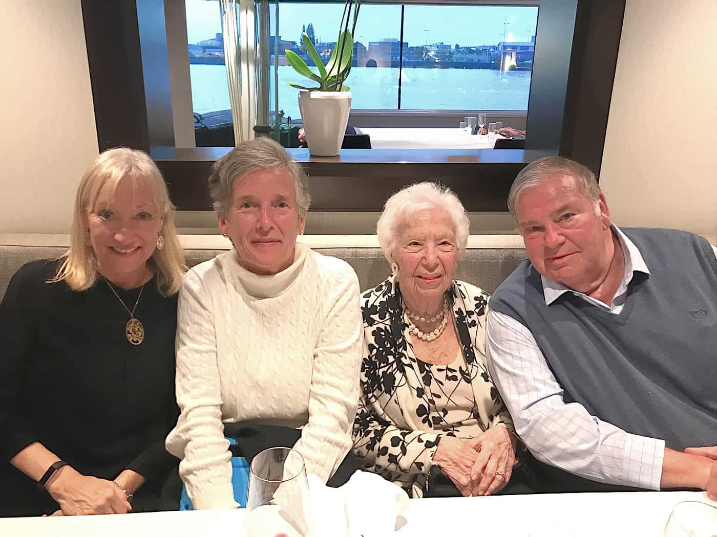 Sherry with new friends sitting together on one side of the dining table.