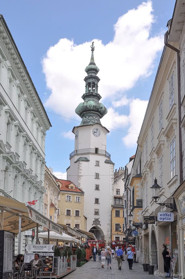 Street with tourists heading to St. Michael's Gate entrance.