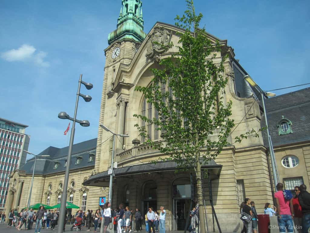 Front of Luxembourg city train station with people milling about at the main entrance.