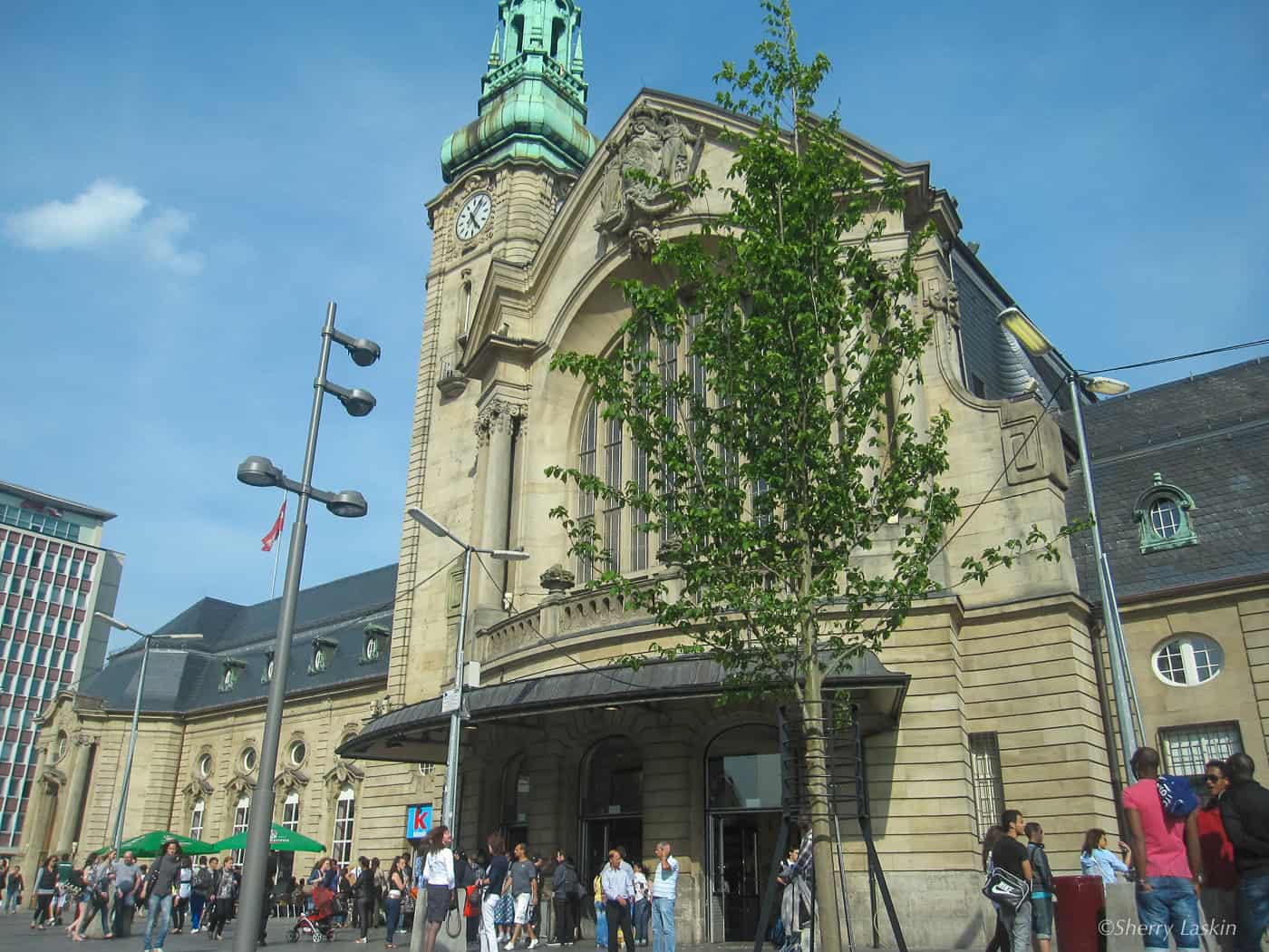 Front of Luxembourg city train station with people milling about at the main entrance.