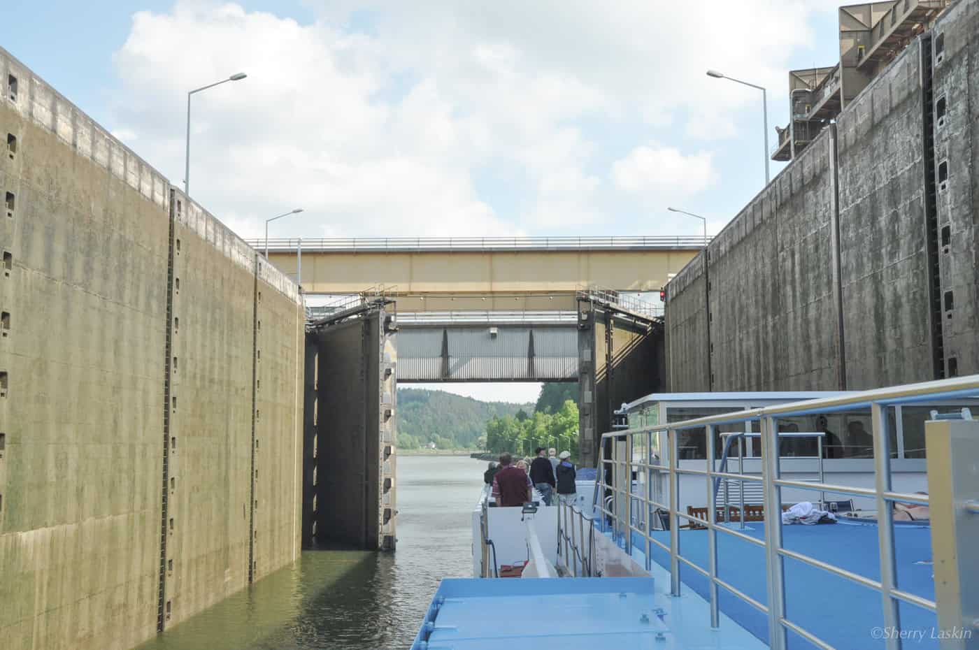 River ship going through Rhine river lock as lock gates open.