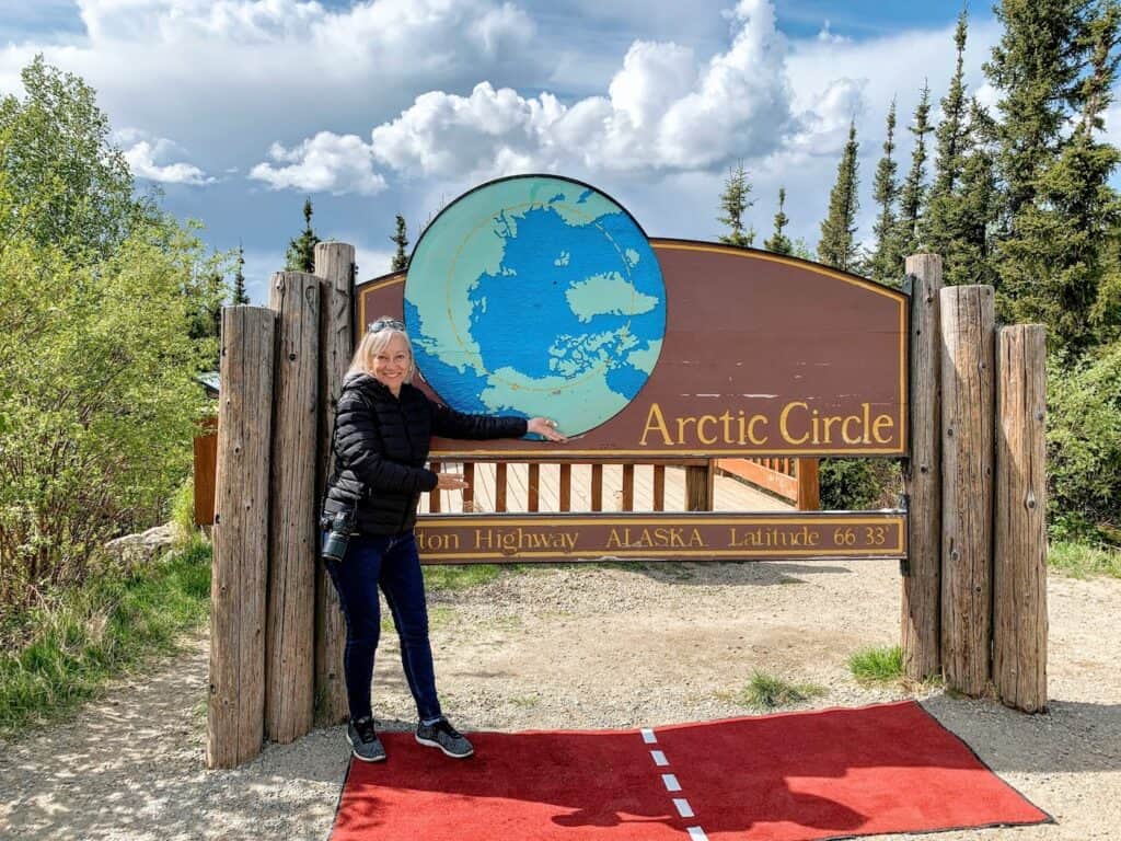 Sherry standing at the Arctic Circle sign.