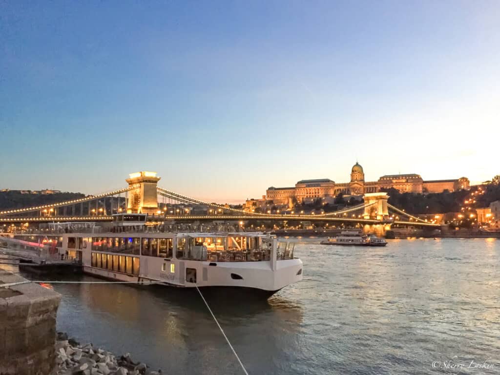 Viking river ship docked in Budapest with Chain Bridge behind it.