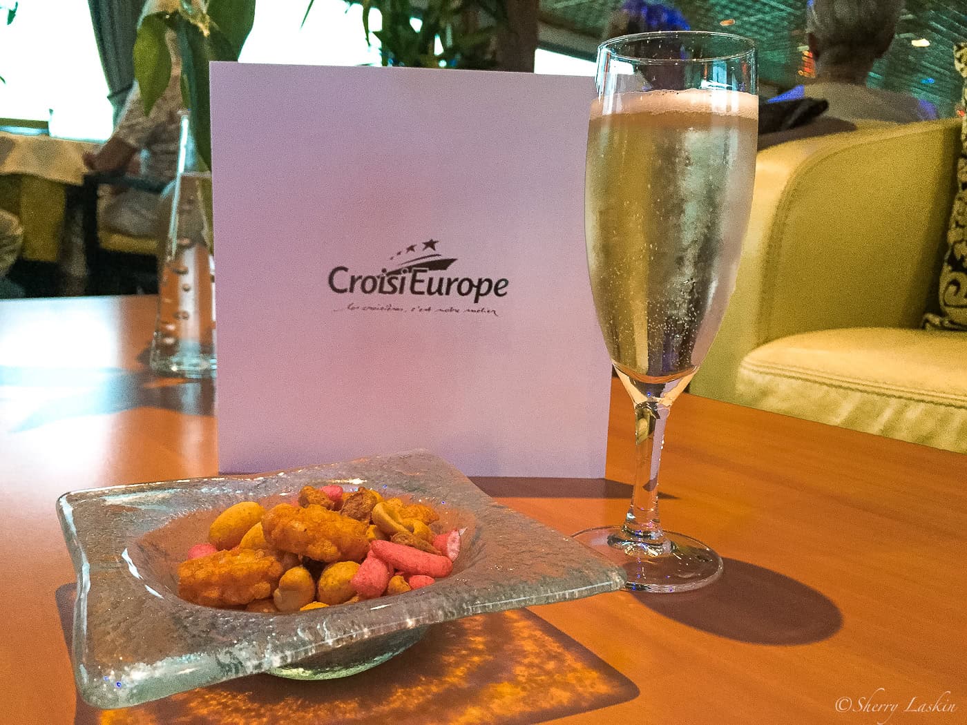 Welcome aboard champagne glass and mixed nuts snacks.